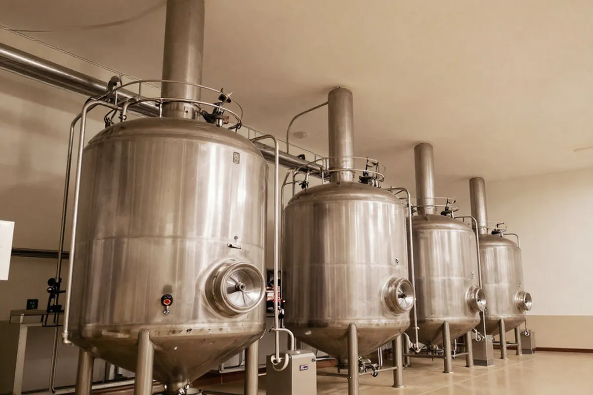 Four fermentation vessels standing in a production hall